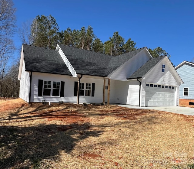 view of front of house featuring concrete driveway, an attached garage, and a shingled roof