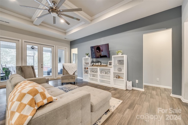 living room featuring ceiling fan, hardwood / wood-style floors, crown molding, coffered ceiling, and french doors