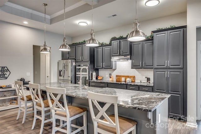 kitchen featuring a large island, stainless steel appliances, and hanging light fixtures