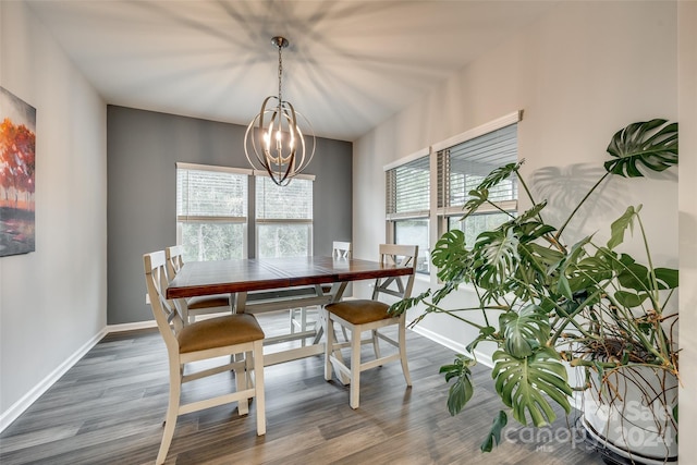 dining area featuring dark wood-type flooring, a wealth of natural light, and a chandelier