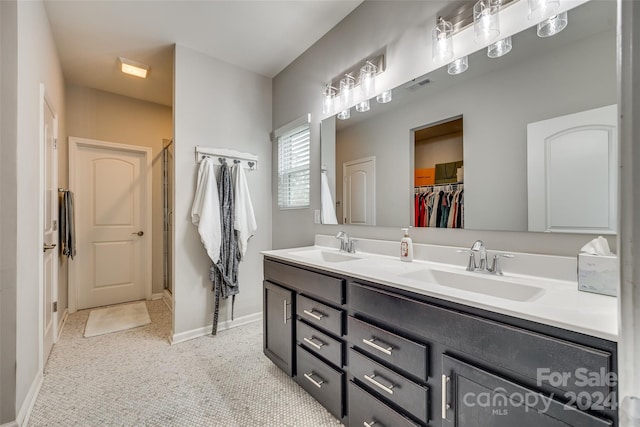 bathroom featuring tile patterned flooring, an enclosed shower, and vanity