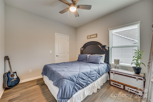 bedroom with hardwood / wood-style floors, ceiling fan, and multiple windows