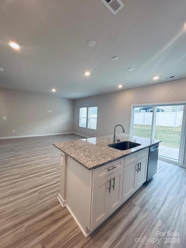 kitchen featuring dishwasher, sink, a healthy amount of sunlight, an island with sink, and white cabinets