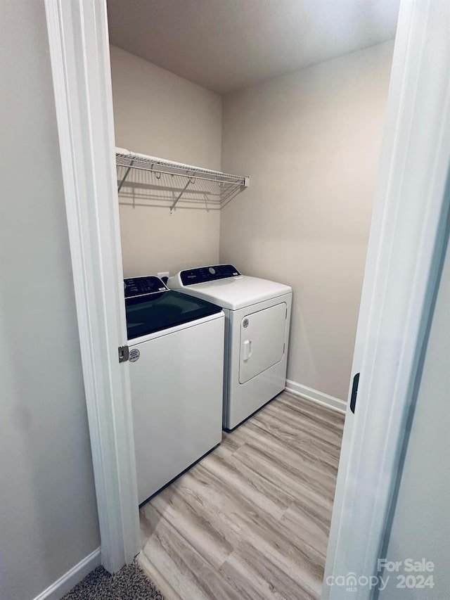 washroom featuring light hardwood / wood-style floors and washing machine and clothes dryer