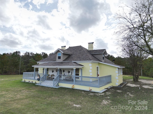 2034 Haileys Ferry Rd, Lilesville, NC 28091 - back of house with a chimney, a yard, roof with shingles, a porch, and stucco siding