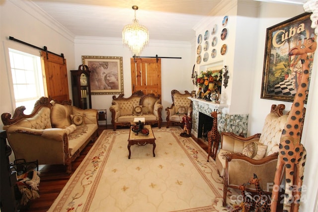 living room featuring hardwood / wood-style floors, a barn door, ornamental molding, and a chandelier