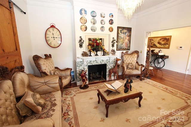 living room with an inviting chandelier, wood-type flooring, and ornamental molding