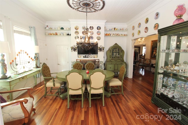 dining area with dark hardwood / wood-style floors, ornamental molding, and a chandelier