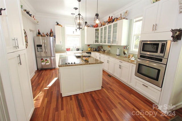 kitchen with a kitchen island, light stone countertops, stainless steel appliances, and dark wood-type flooring