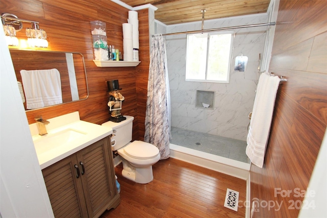 bathroom featuring vanity, hardwood / wood-style flooring, walk in shower, and wood walls