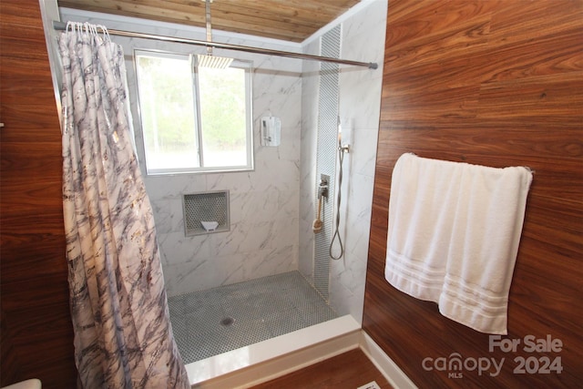 bathroom with a shower with curtain, wooden walls, and wooden ceiling