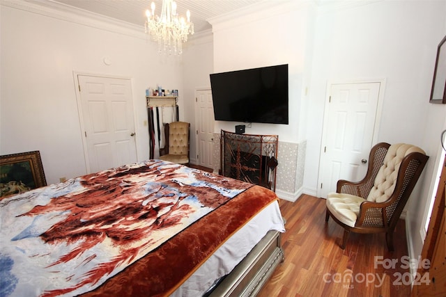 bedroom featuring ornamental molding, a chandelier, and light wood-type flooring