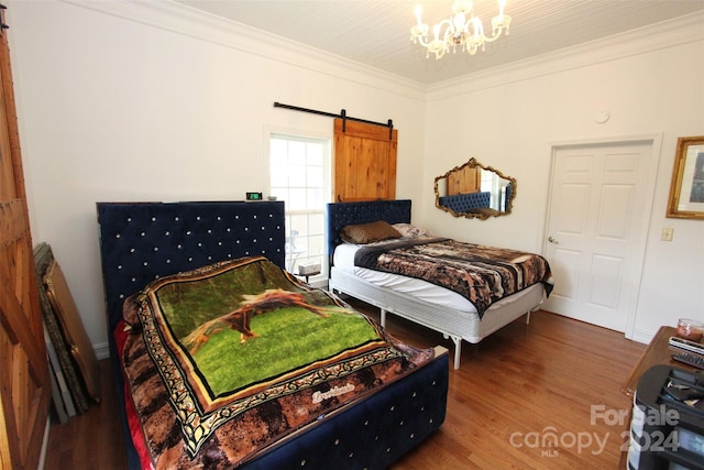 bedroom featuring hardwood / wood-style floors, a barn door, crown molding, and a chandelier