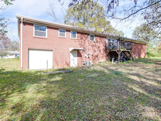 rear view of house with a lawn, central air condition unit, a deck, and a garage