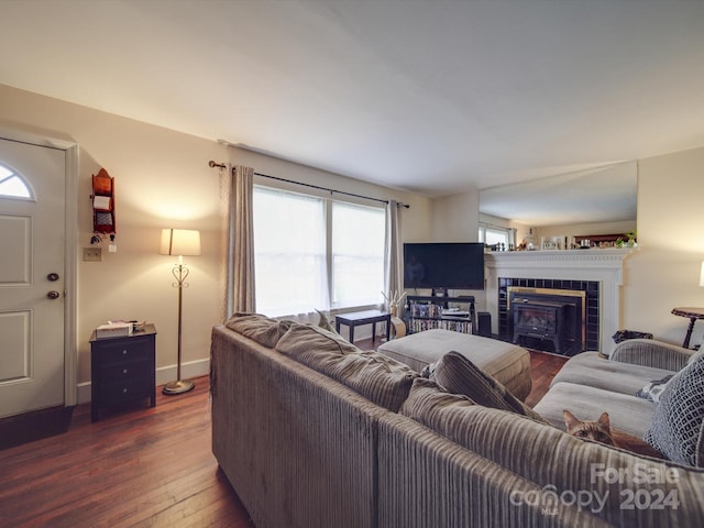 living room featuring dark hardwood / wood-style floors and a tile fireplace