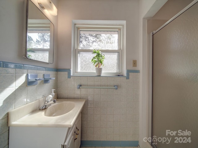 bathroom featuring vanity, an enclosed shower, and tile walls