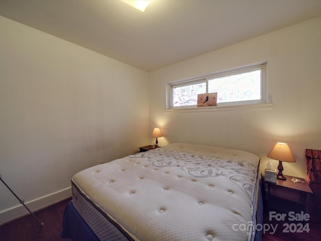 bedroom with dark wood-type flooring