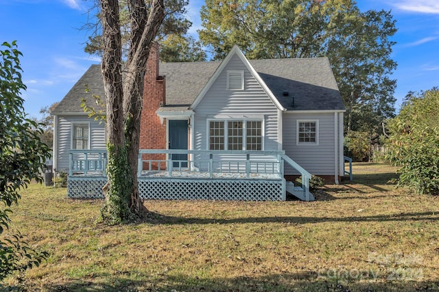 rear view of house featuring a lawn and a wooden deck