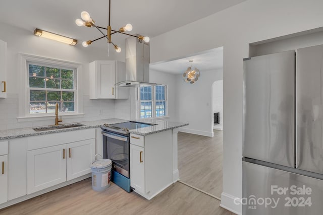 kitchen with island exhaust hood, appliances with stainless steel finishes, decorative backsplash, sink, and white cabinets