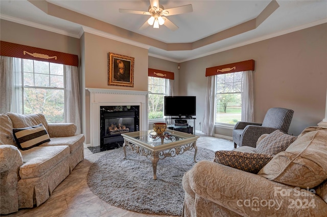 living room featuring a wealth of natural light, ceiling fan, and crown molding