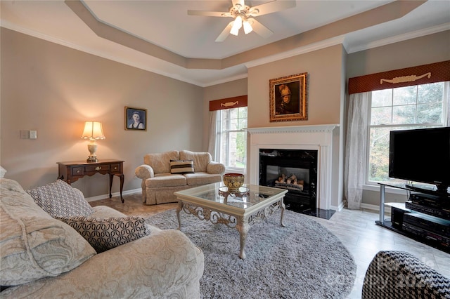 tiled living room with a premium fireplace, a healthy amount of sunlight, crown molding, and ceiling fan