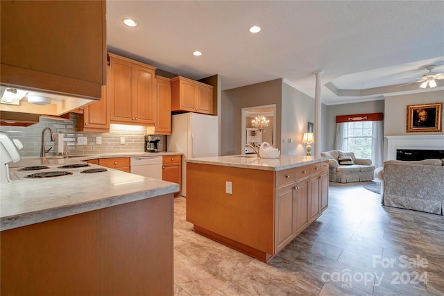 kitchen with sink, light brown cabinets, backsplash, an island with sink, and dishwasher