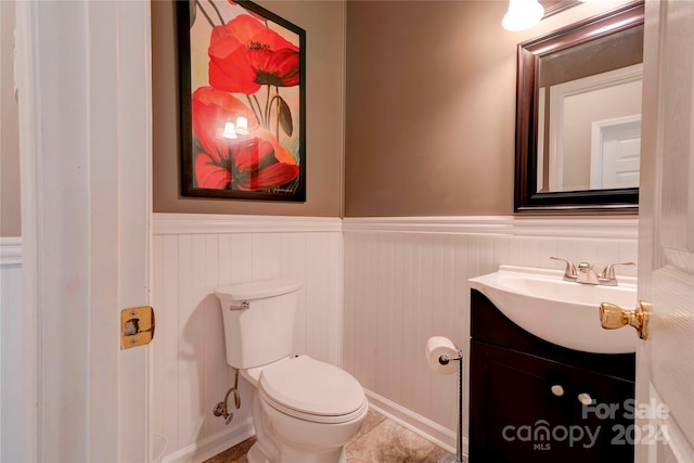 bathroom with tile patterned flooring, vanity, and toilet