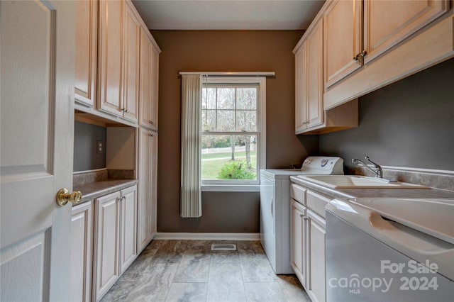 washroom featuring cabinets, sink, and independent washer and dryer