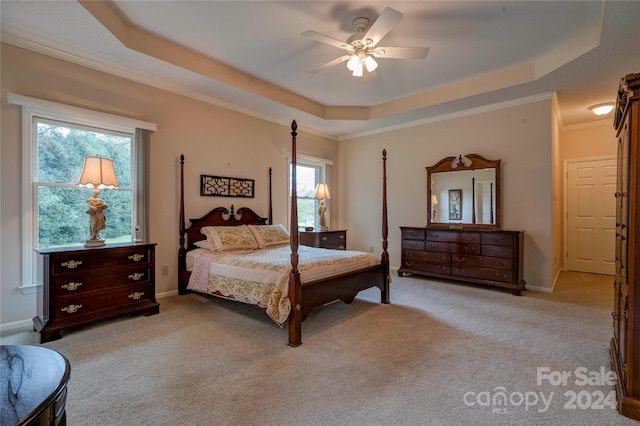 carpeted bedroom featuring ornamental molding, multiple windows, ceiling fan, and a raised ceiling