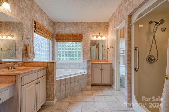 bathroom with tiled bath, vanity, a textured ceiling, tile patterned flooring, and toilet