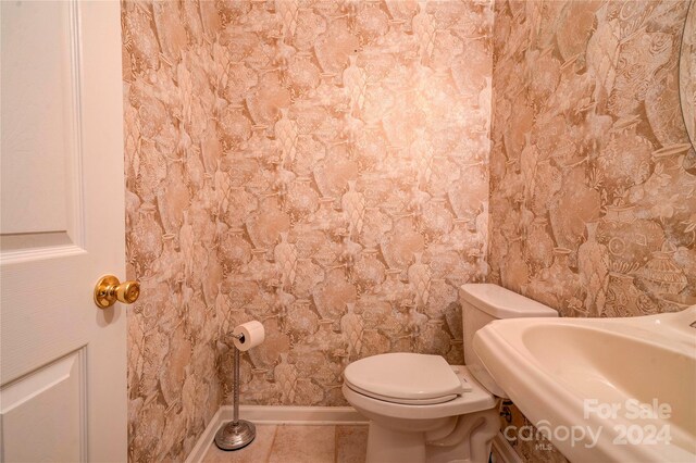 bathroom featuring tile patterned floors, toilet, and sink