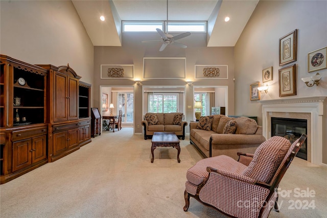 carpeted living room with high vaulted ceiling and ceiling fan