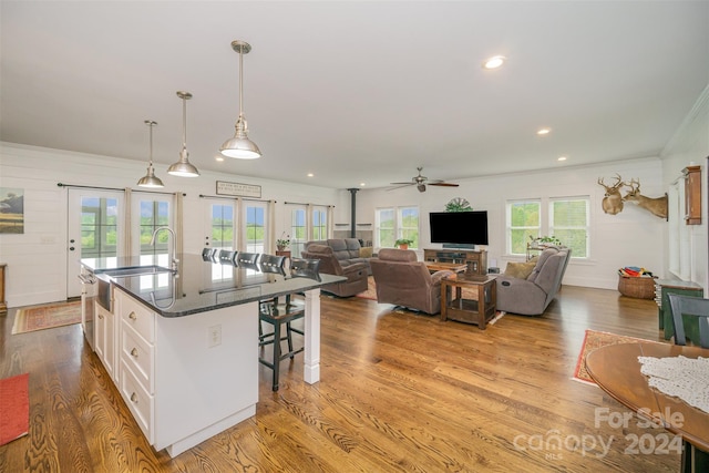 kitchen featuring pendant lighting, white cabinetry, a wealth of natural light, and sink