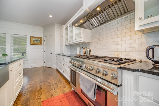 kitchen featuring double oven range, premium range hood, dark wood-type flooring, decorative backsplash, and white cabinetry