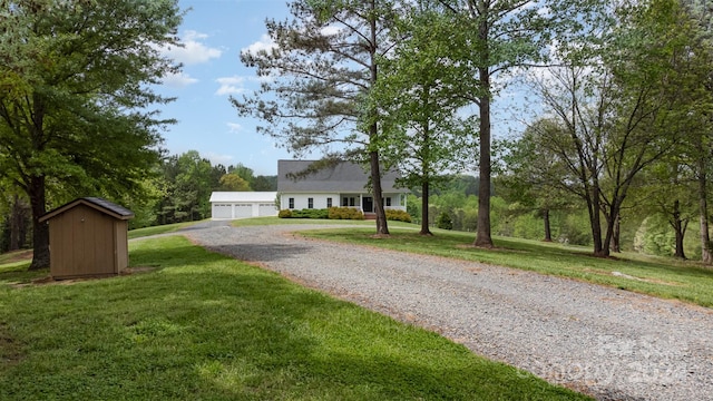 view of front of home featuring a front yard and a shed