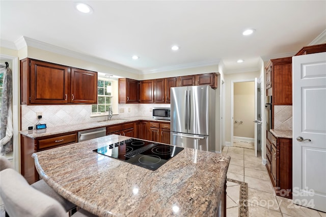 kitchen with ornamental molding, appliances with stainless steel finishes, and a breakfast bar