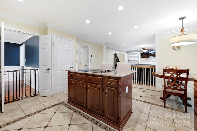 kitchen with black electric cooktop, a center island, ornamental molding, light stone countertops, and pendant lighting