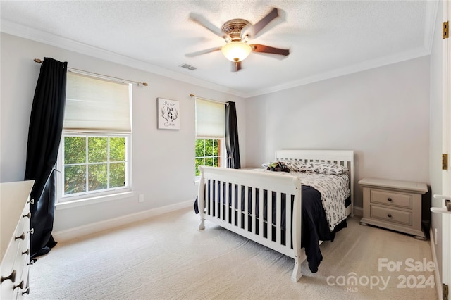 carpeted bedroom featuring ceiling fan, a textured ceiling, and crown molding