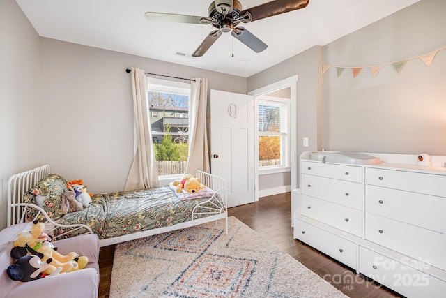 bedroom with dark hardwood / wood-style flooring, radiator heating unit, and ceiling fan