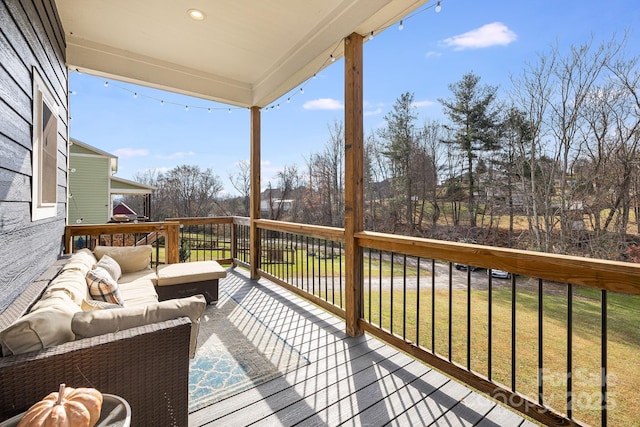 wooden deck with a yard and outdoor lounge area