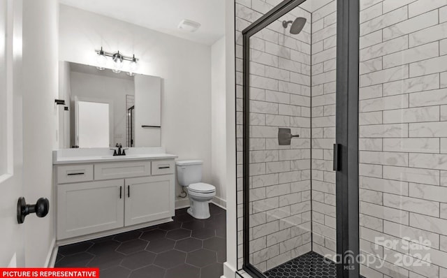 bathroom featuring toilet, vanity, tile patterned floors, and a shower with door