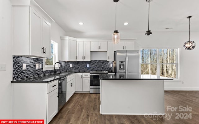 kitchen featuring white cabinetry, stainless steel appliances, and decorative light fixtures