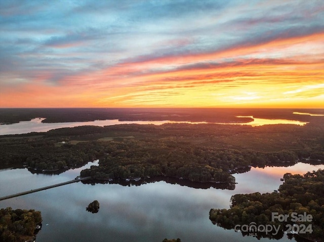 aerial view at dusk featuring a water view