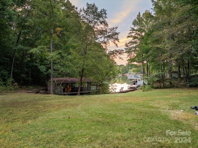 yard at dusk featuring a water view