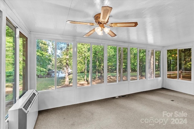 unfurnished sunroom featuring an AC wall unit and ceiling fan