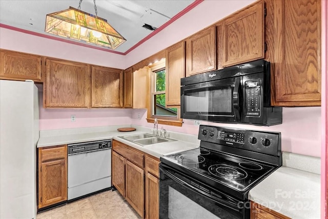 kitchen with sink, black appliances, lofted ceiling, crown molding, and pendant lighting