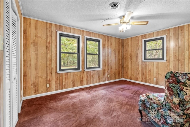 unfurnished room with wood walls and dark carpet