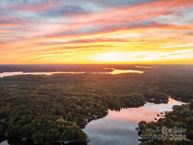 aerial view at dusk featuring a water view