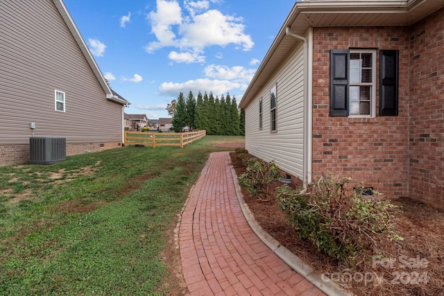 view of property exterior with a yard and central AC