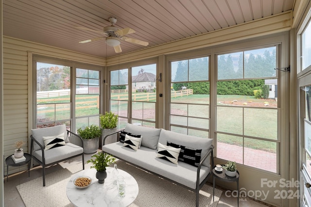 sunroom / solarium featuring plenty of natural light, ceiling fan, and wood ceiling